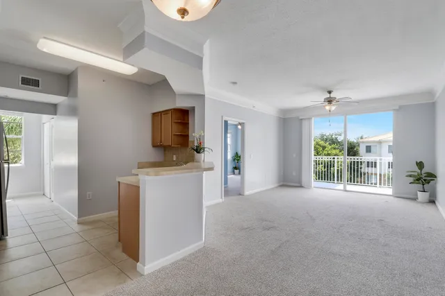an empty room with windows and a ceiling fan