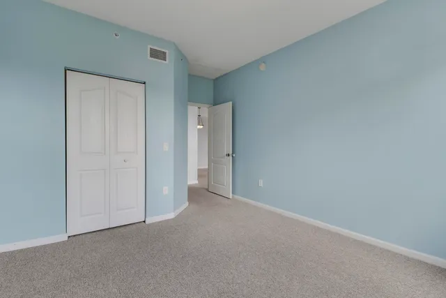 a view of an empty room with chandelier fan