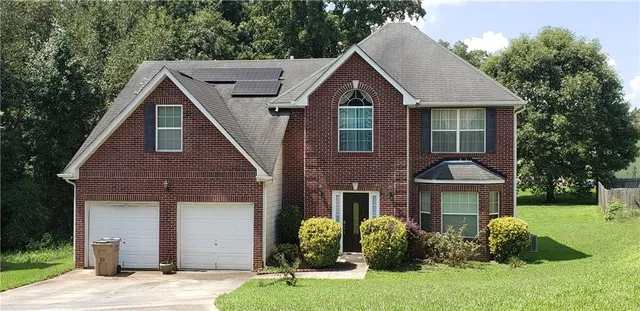 a front view of a house with a yard and garage