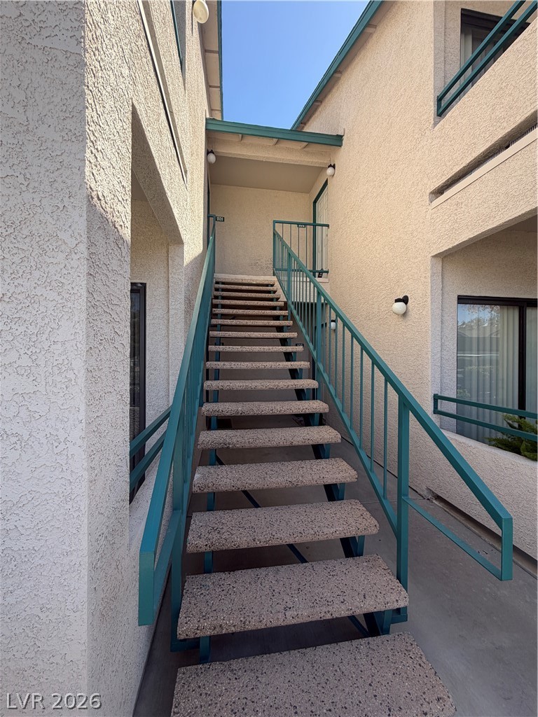 5271 South Lindell Road, Unit 202 Las Vegas, NV 89118 - Photo 5 of 27 Bold teal railings lead up textured concrete stairs, connecting levels of this modern building.