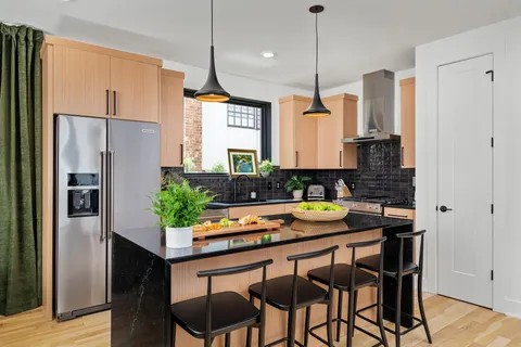 a kitchen with stainless steel appliances granite countertop a refrigerator a sink and a stove