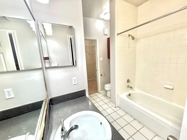 a bathroom with a tub a sink and a mirror