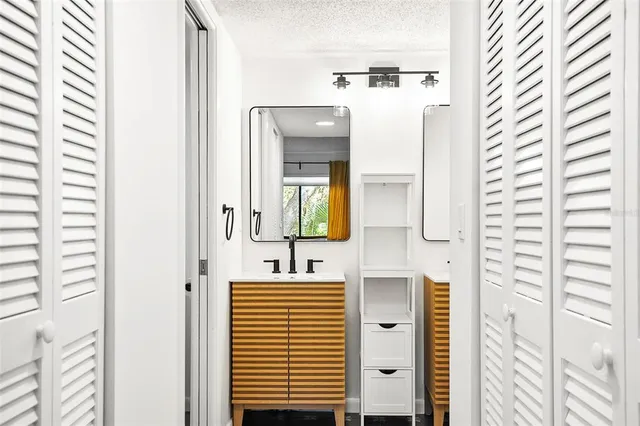 a bedroom with a bed and lamp on dresser