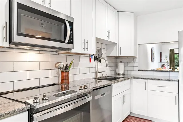 a dining room with wooden floor a chandelier a glass table and chairs
