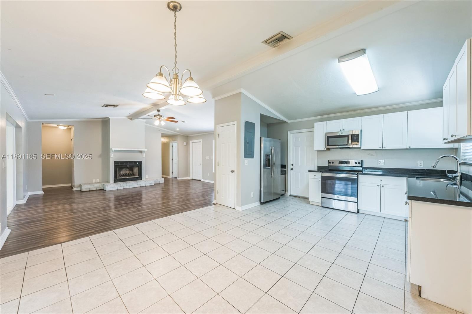 10108 Windtree Lane Boca Raton, FL 33428 - Photo 3 of 15 a large kitchen with kitchen island granite countertop a refrigerator a stove a sink dishwasher and white cabinets with wooden floor