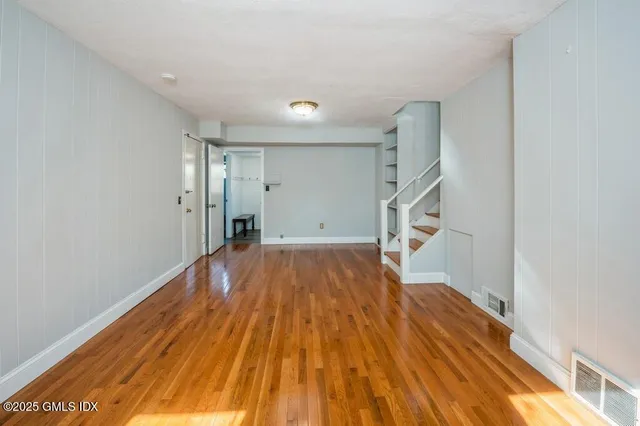 a view of empty room with wooden floor