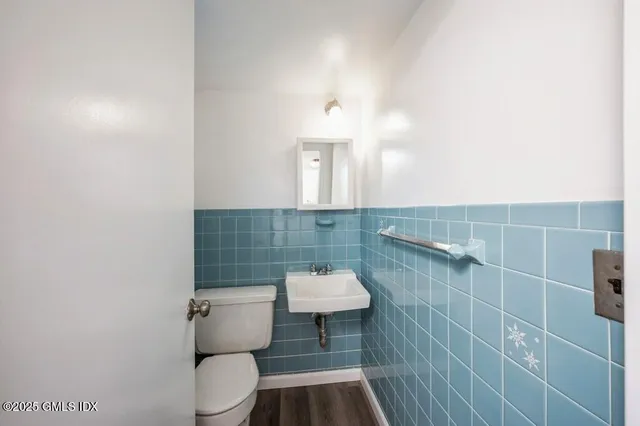 a bathroom with a sink a toilet and a mirror