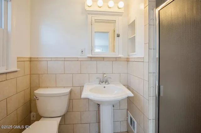 a bathroom with a sink toilet and a mirror