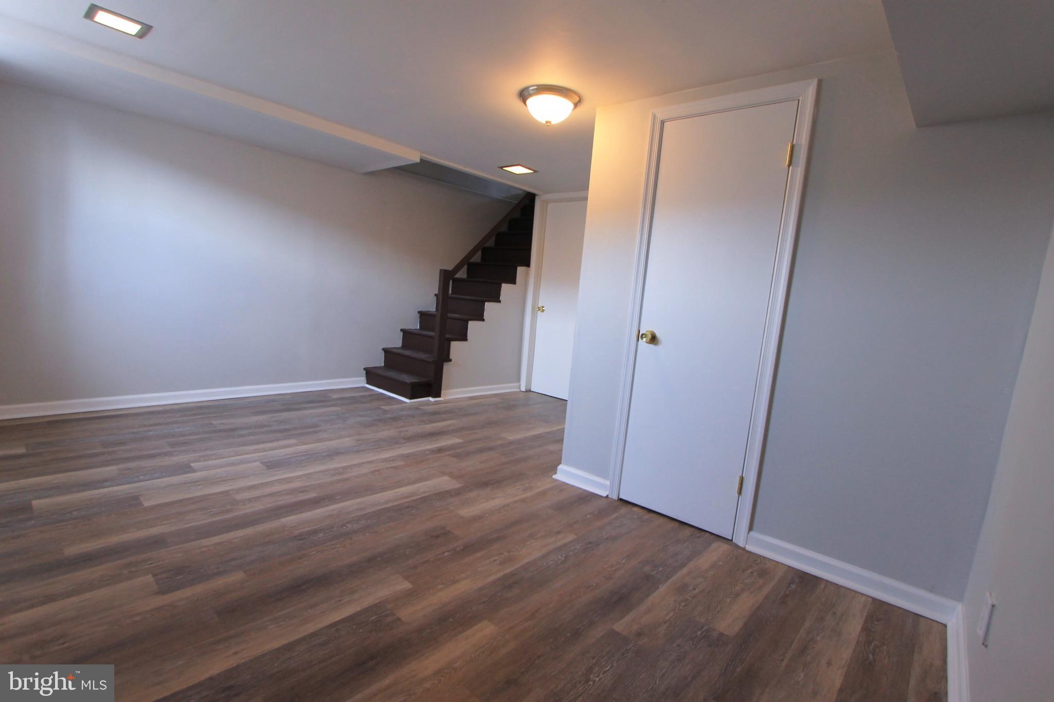 8613 Gilbert Street Philadelphia, PA 19150 - Photo 10 of 28 a view of an empty room with wooden floor and stairs