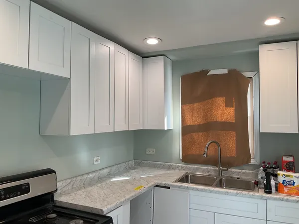 a kitchen with a sink cabinets and window