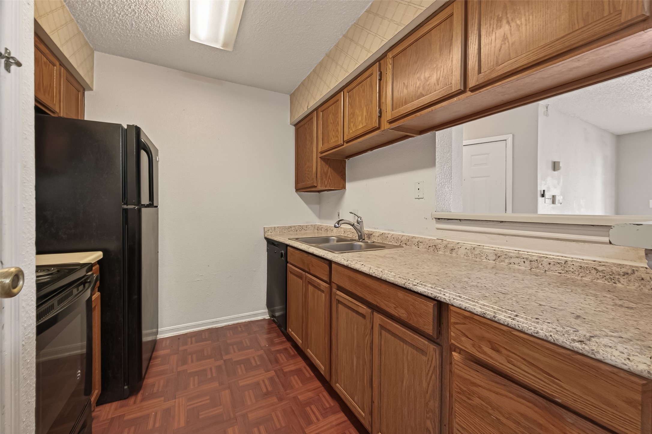 10101 South Gessner Road, Unit 307 Houston, TX 77071 - Photo 2 of 20 a kitchen with granite countertop a refrigerator and a sink