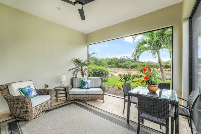 a living room with patio furniture and a potted plant