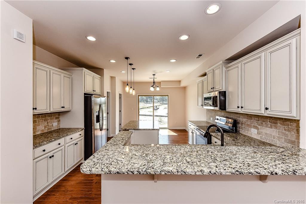 110 Layla Drive, Unit CC180 Tega Cay, SC 29708 - Photo 3 of 23 a kitchen with stainless steel appliances granite countertop a sink stove refrigerator and cabinets