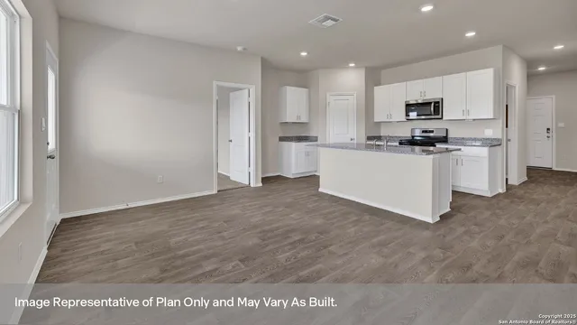 a kitchen with stainless steel appliances granite countertop a refrigerator oven a sink a stove and white cabinets