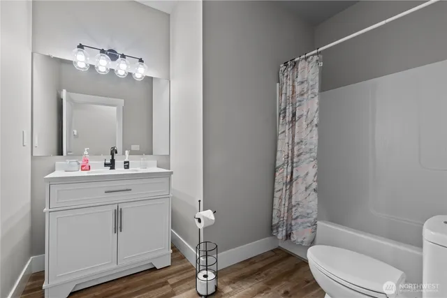 a bathroom with a sink a toilet a mirror and a shower