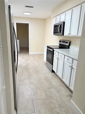 a kitchen with stainless steel appliances a refrigerator sink and microwave