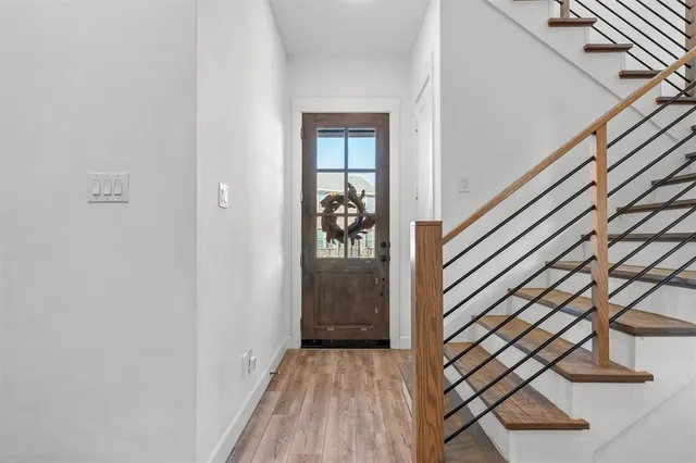 a view of a hallway with wooden floor and staircase