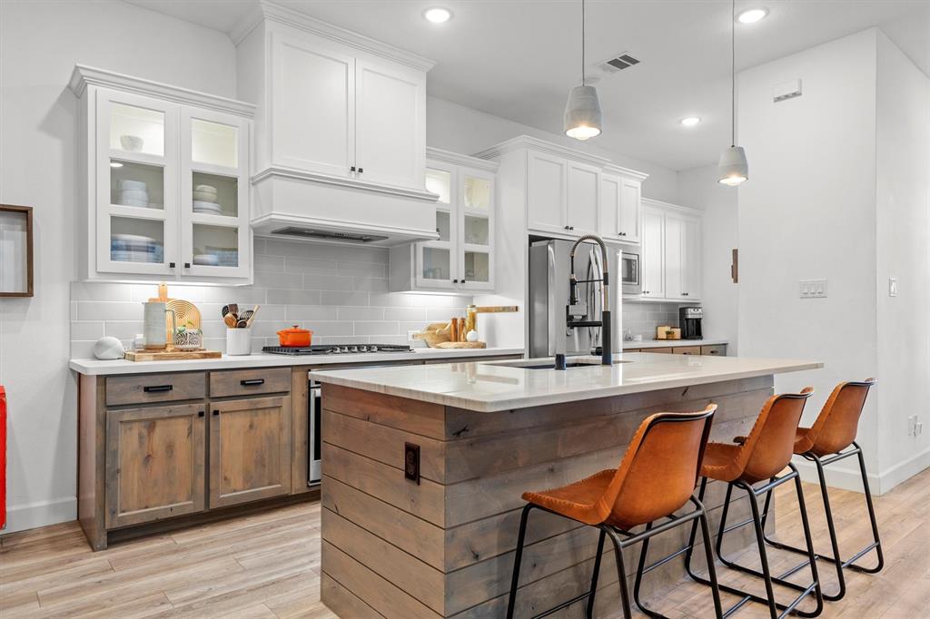 813 Forest Lake Road Flower Mound, TX 75028 - Photo 5 of 39 a kitchen with stainless steel appliances granite countertop a sink a stove a refrigerator and island with wooden floor