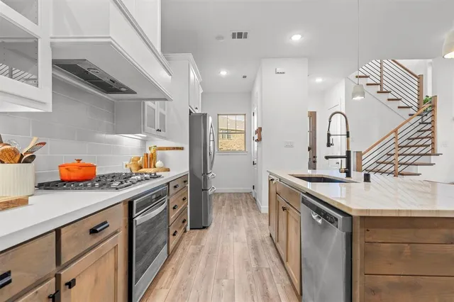 a kitchen with granite countertop a sink stainless steel appliances and cabinets