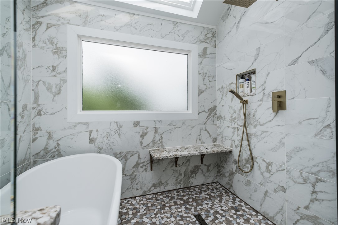 1415 Harbor Drive Northwest Canton, OH 44708 - Photo 32 of 46 Owners Bathroom featuring tile walls, plus walk in shower, and a skylight