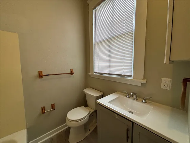 a bathroom with a sink a toilet and a mirror