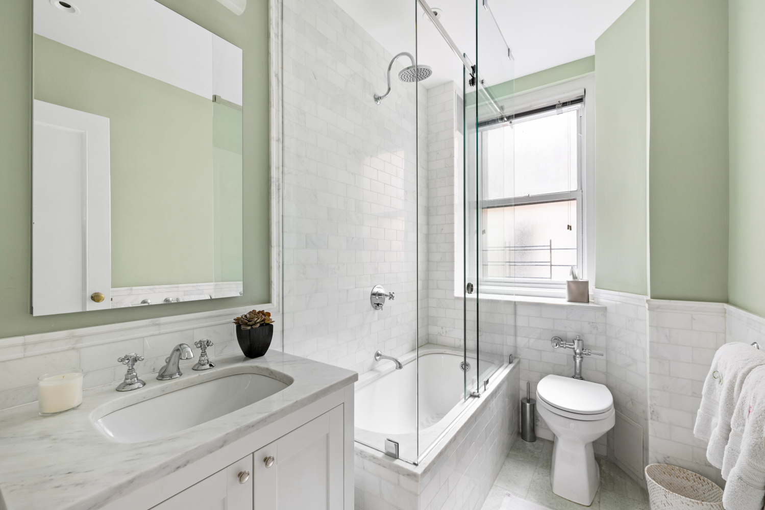 114 East 84th Street, Unit 8B Manhattan, NY 10028 - Photo 11 of 15 a bathroom with a toilet sink a mirror a bathtub and shower