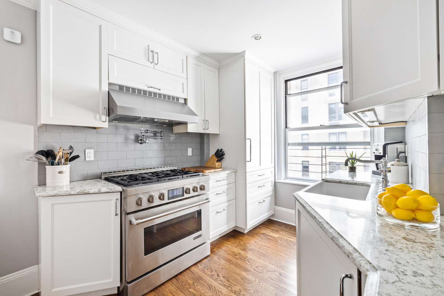 114 East 84th Street, Unit 8B Manhattan, NY 10028 - Photo 7 of 15 a kitchen with a stove a sink and a refrigerator
