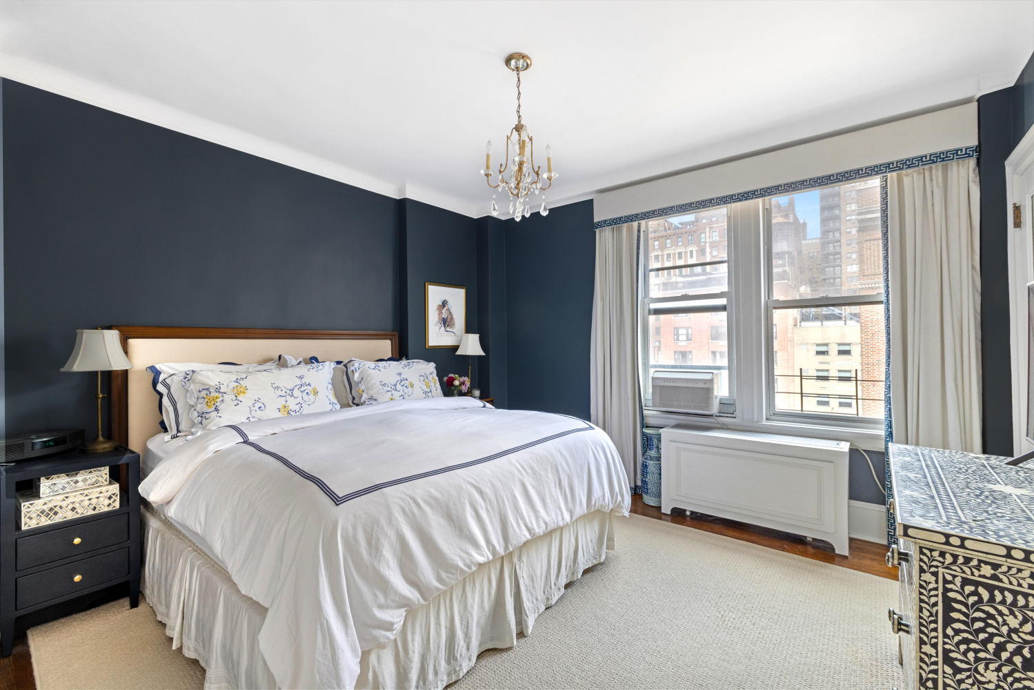 114 East 84th Street, Unit 8B Manhattan, NY 10028 - Photo 8 of 15 a spacious bedroom with a bed and a chandelier