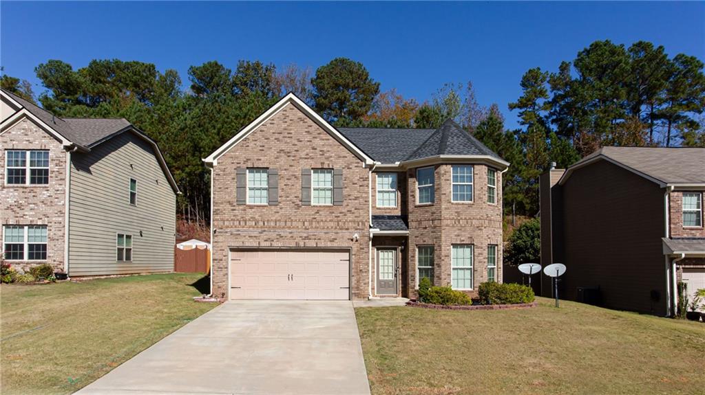 a front view of a house with a yard and garage
