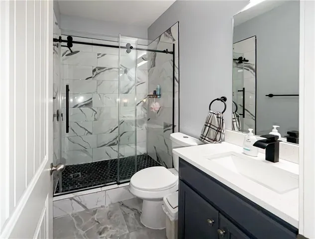 a bathroom with a sink a toilet and shower