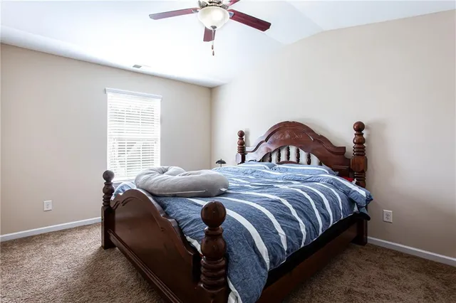 a bedroom with a bed and a ceiling fan