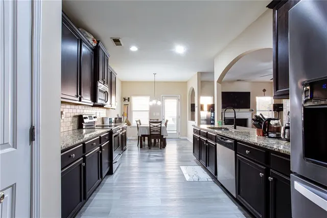 a large kitchen with stainless steel appliances lots of counter top space