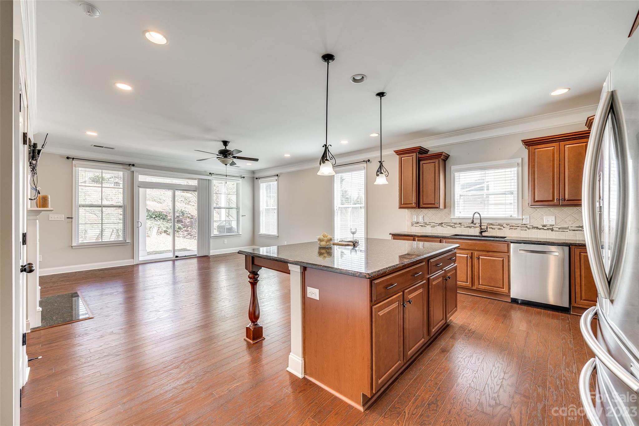 198 Annatto Way Tega Cay, SC 29708 - Photo 11 of 45 a kitchen with granite countertop a stove a sink a refrigerator and wooden floor