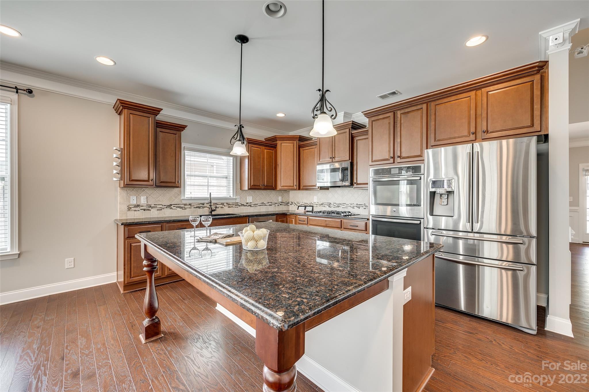 198 Annatto Way Tega Cay, SC 29708 - Photo 12 of 45 a kitchen with stainless steel appliances granite countertop a sink a refrigerator and wooden floor