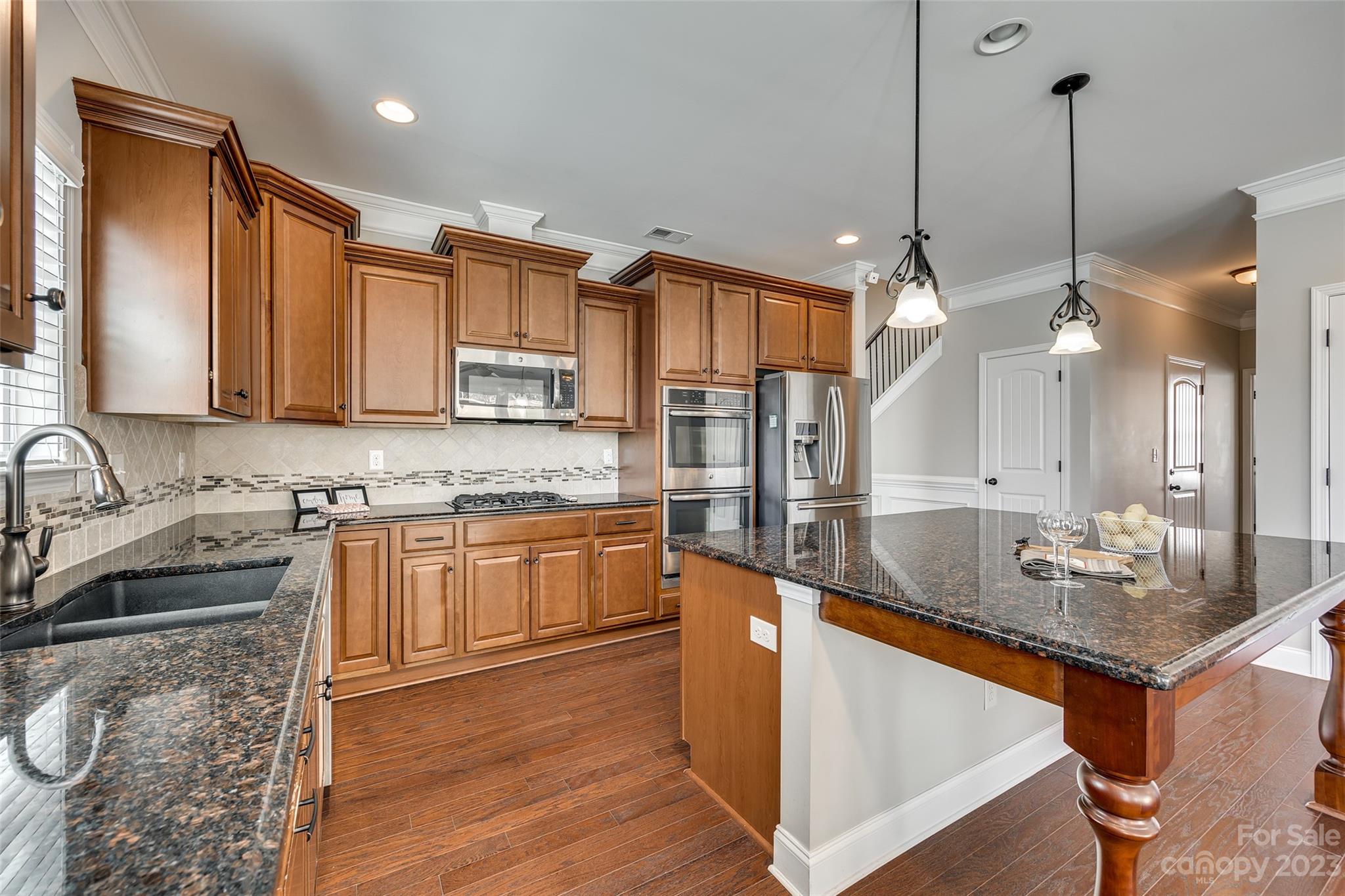 198 Annatto Way Tega Cay, SC 29708 - Photo 13 of 45 a kitchen with stainless steel appliances granite countertop a sink a stove and a wooden floors