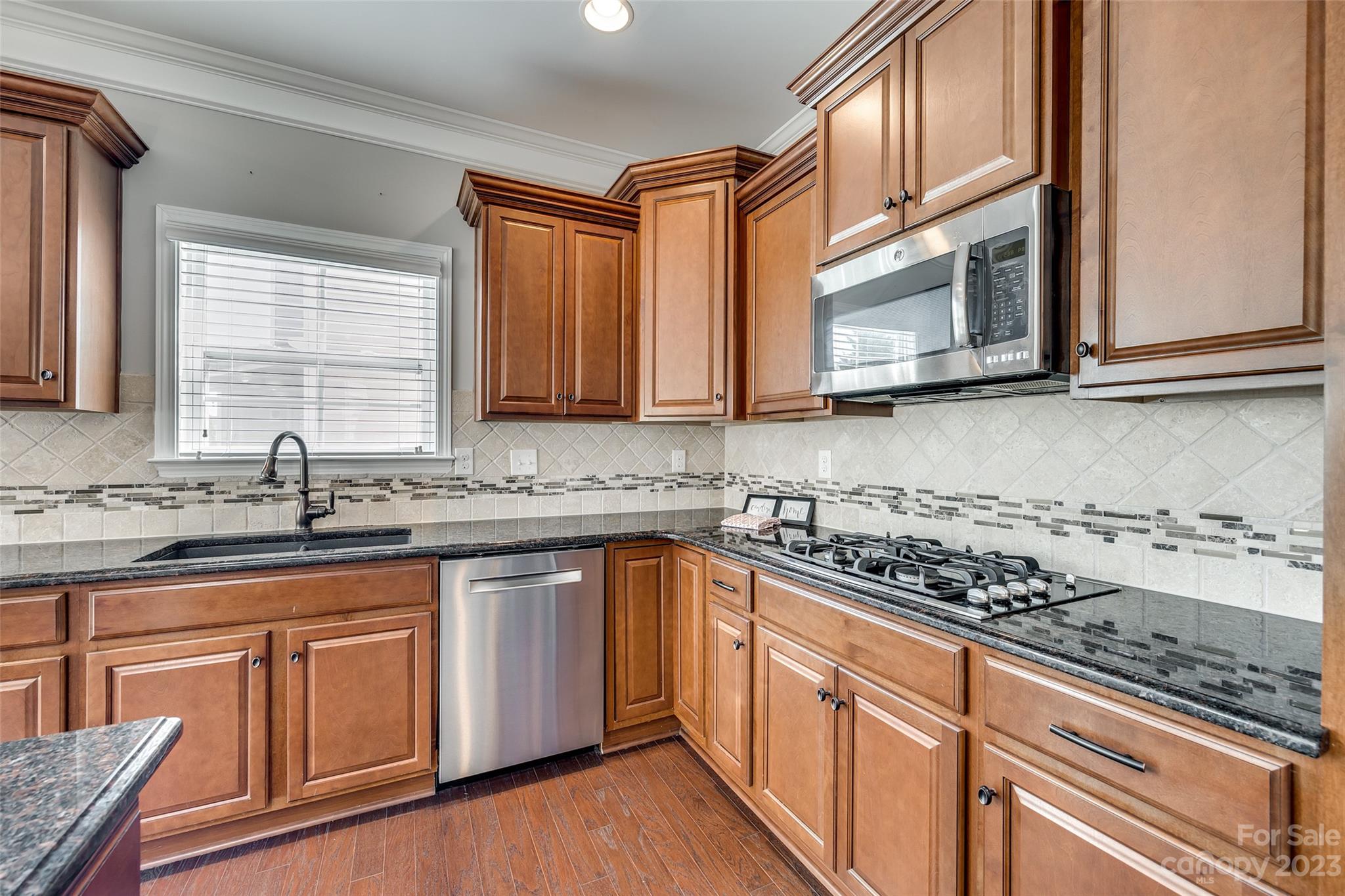 198 Annatto Way Tega Cay, SC 29708 - Photo 14 of 45 a kitchen with stainless steel appliances granite countertop a sink stove microwave and cabinets