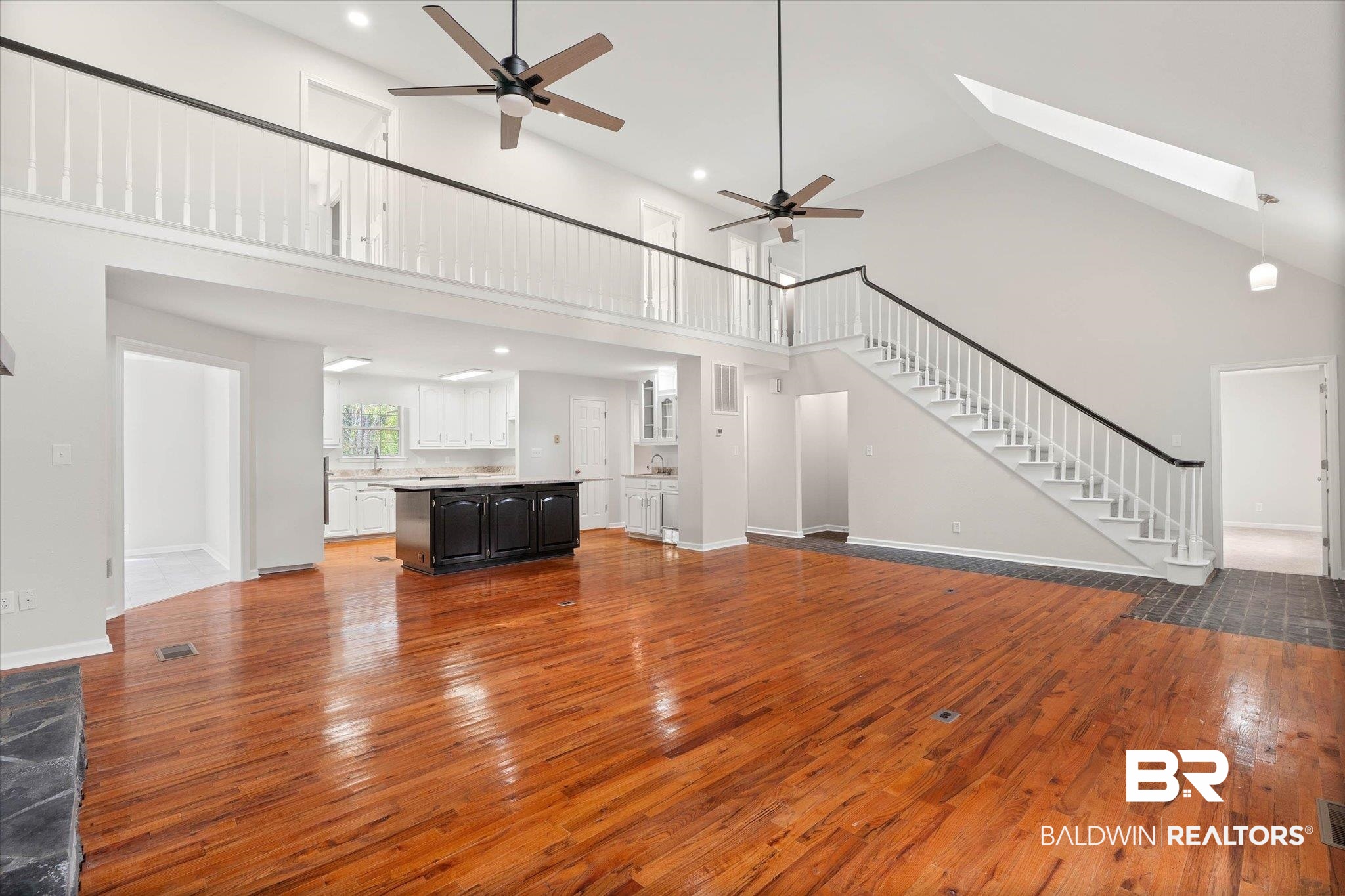 106 Melanie Loop Daphne, AL 36526 - Photo 5 of 45 Unfurnished living room featuring ceiling fan, light wood-style floors, a skylight, a high ceiling, and recessed lighting