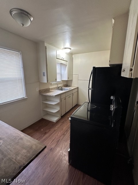 21400 Watson Road Maple Heights, OH 44137 - Photo 3 of 24 Kitchen with white cabinetry, black fridge, sink, and dark wood-type flooring