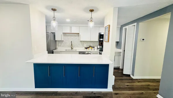 a kitchen with kitchen island a sink appliances and cabinets