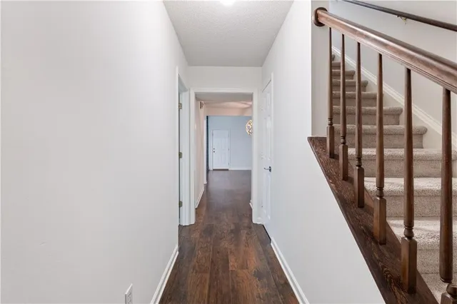 a view of a hallway with wooden floor and staircase