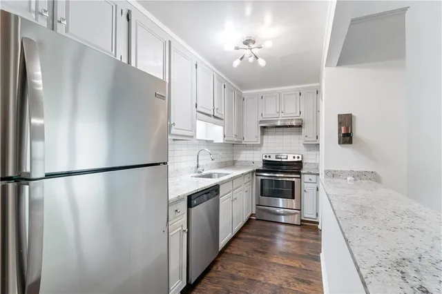 a kitchen with stainless steel appliances a refrigerator sink and cabinets