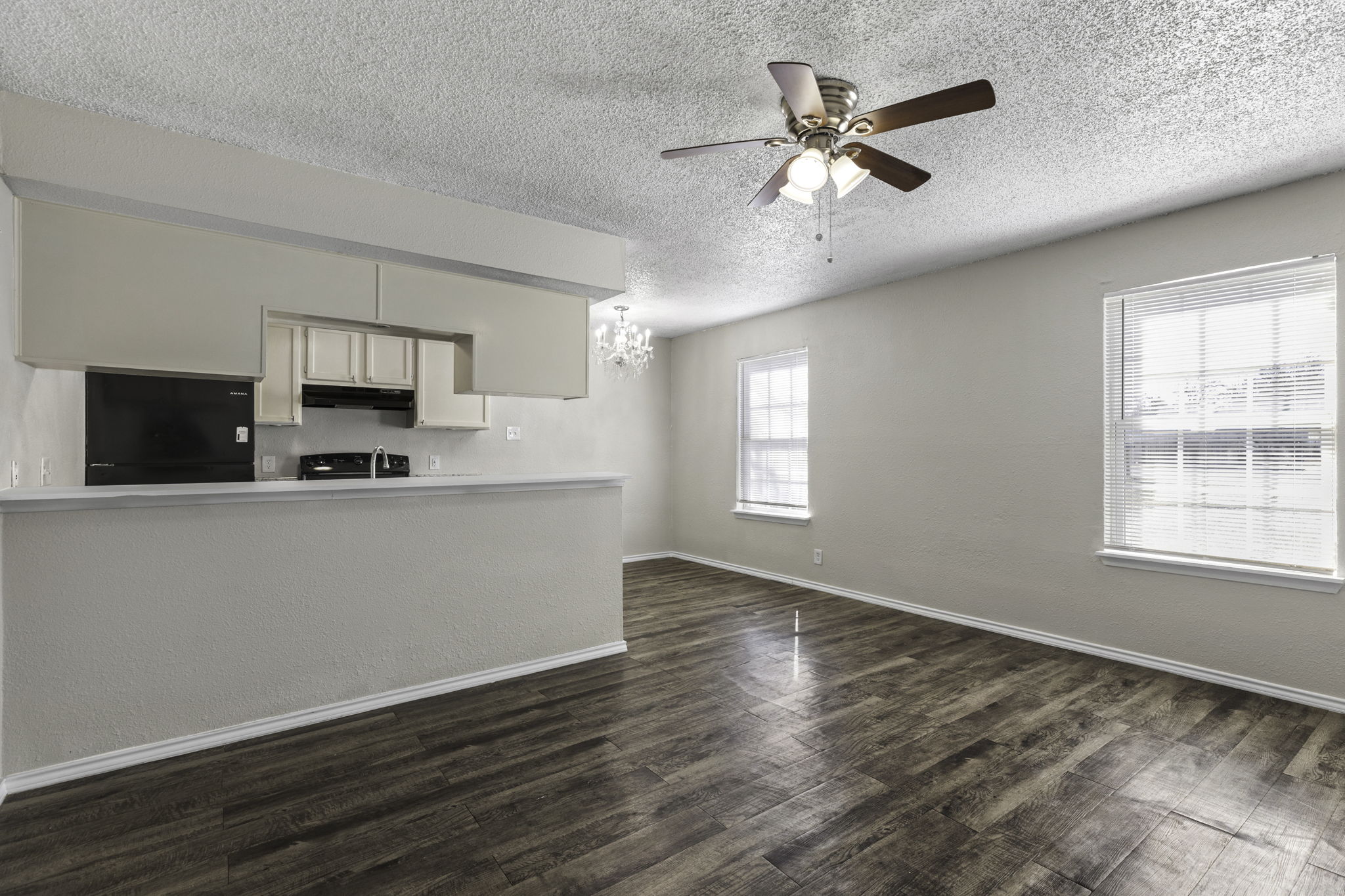 6110 Wheless Cove, Unit E Austin, TX 78723 - Photo 6 of 15 Kitchen featuring light countertops, refrigerator, a textured ceiling, dark wood-style floors, and a chandelier