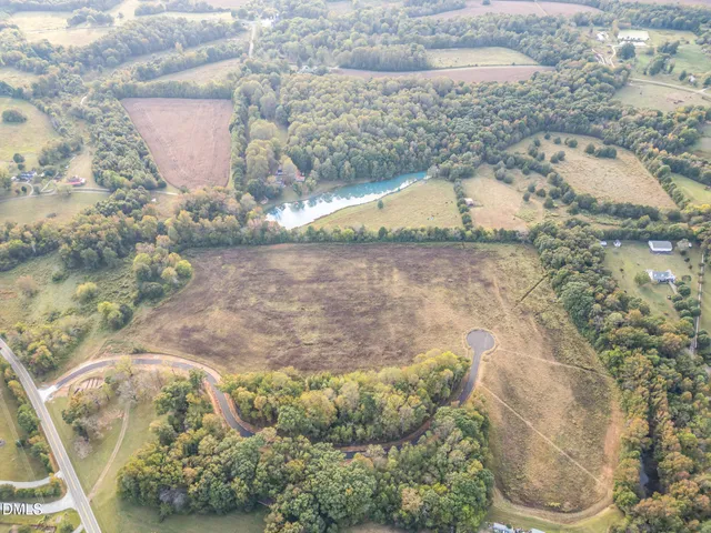 an aerial view of a houses with a yard and lake view