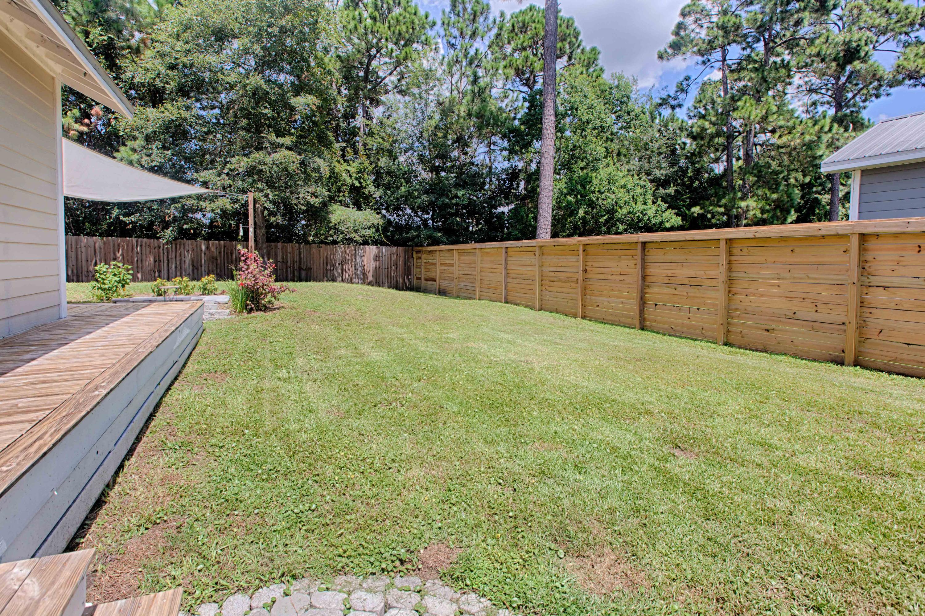 102 Garden Street Santa Rosa Beach, FL 32459 - Photo 4 of 28 a view of a backyard with a wooden fence