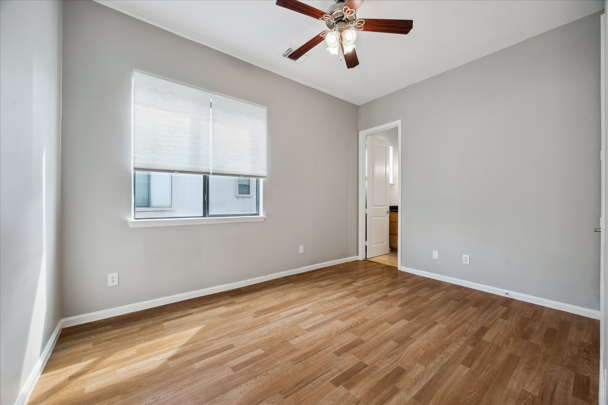802 Waverly Street, Unit D Houston, TX 77007 - Photo 20 of 30 a view of an empty room with wooden floor and a window