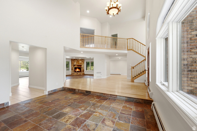 3535 Homestead Road Park City, UT 84098 - Photo 8 of 81 Two-story foyer featuring natural stone tile flooring, a hardwood staircase with wood railings, a multi-level layout, and an upper-level balcony