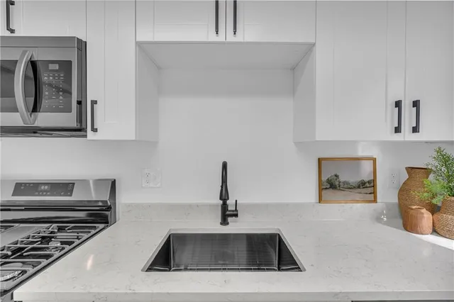 a kitchen with sink a stove and microwave