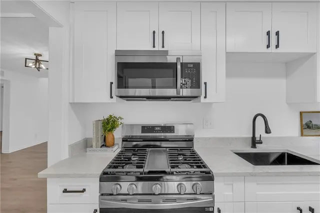 a kitchen with stainless steel appliances granite countertop a stove and a sink