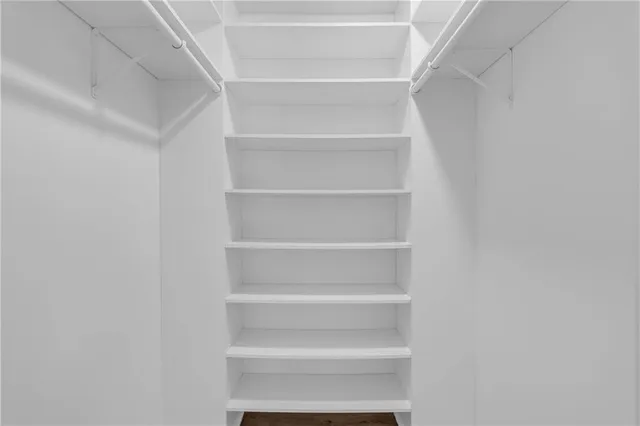 a view of walk in closet with empty racks