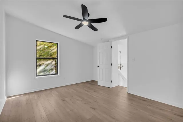 a view of empty room with wooden floor and window